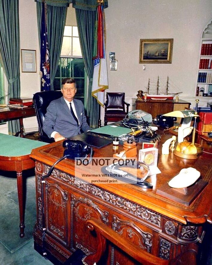 PRESIDENT JOHN F. KENNEDY SITS AT THE 