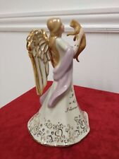 This Purrfect Angel Heirloom in Porcelain displays an angel holding up in front picture