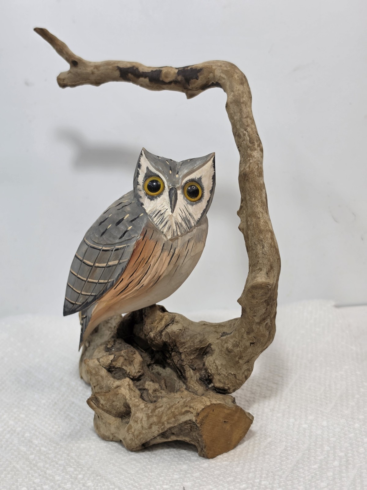 vintage, hand-painted wooden owl carving perched on a natural branch base. vintage, hand-painted wooden owl carving perched on a natural branch base.