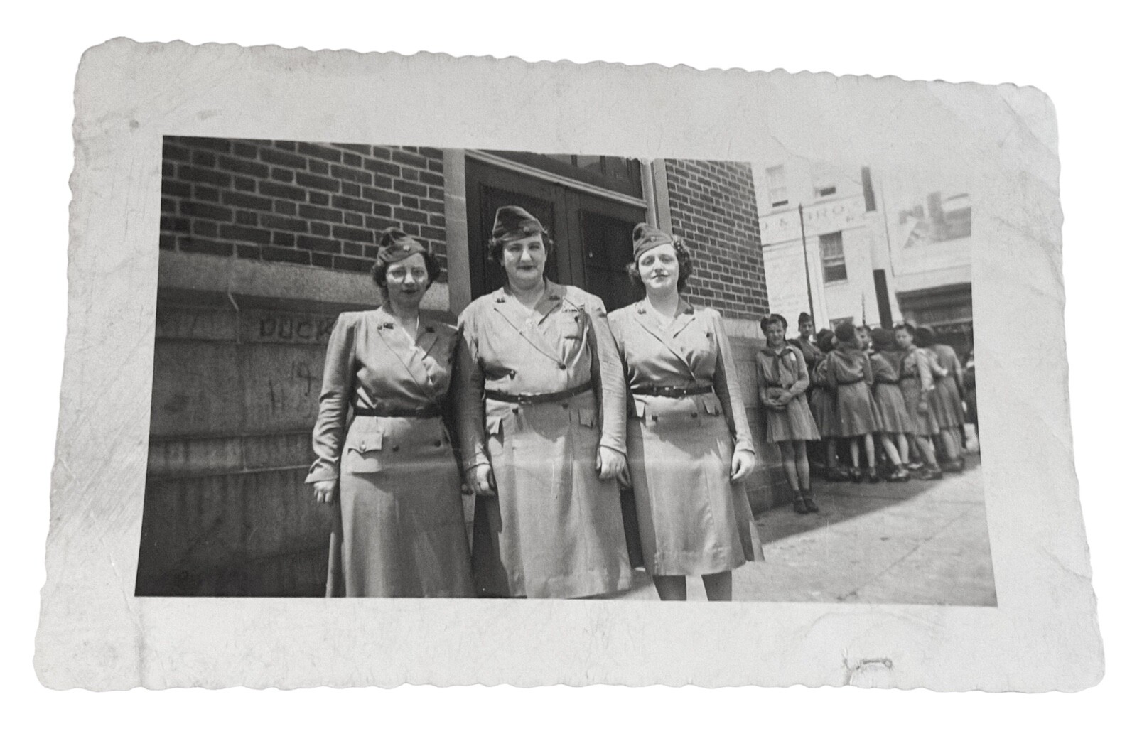 1940s Era Girl Sout Leaders With Troop In Background By Building 1940s Era Girl Sout Leaders With Troop In Background By Building