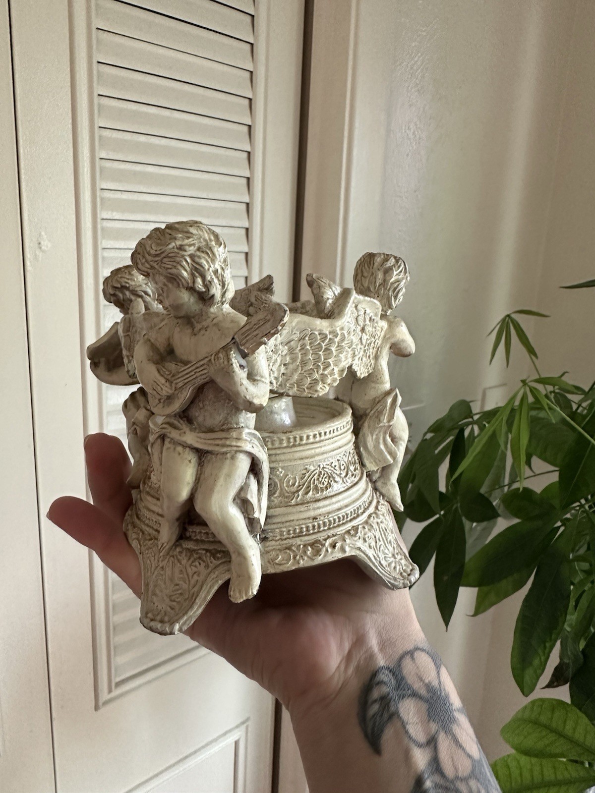 Vintage gold-toned resin candle holder featuring three cherub musicians Vintage gold-toned resin candle holder featuring three cherub musicians